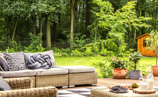 Outdoor Living Spaces Wicker furniture in a backyard.