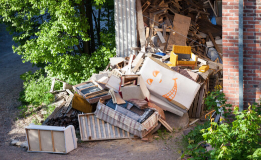 A pile of junk in front of a brick building.