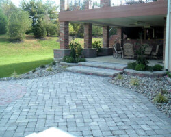 A patio with brick pavers and a fireplace.