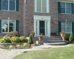 A brick home with a front porch and flower pots.
