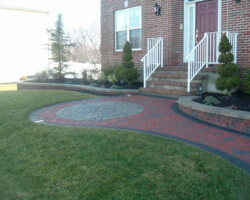 A brick walkway leading to a brick house.