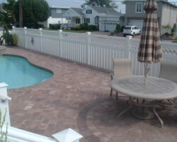 A white picket fence around a pool.